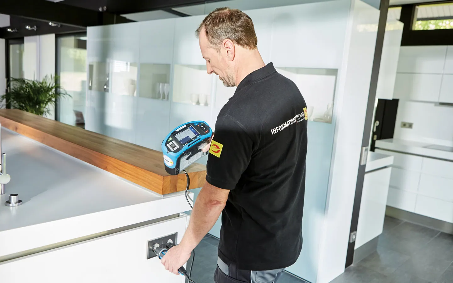 E-CHECK - Mitarbeiter prüft die Steckdosen in der Küche &middot; Huhnold Elektro